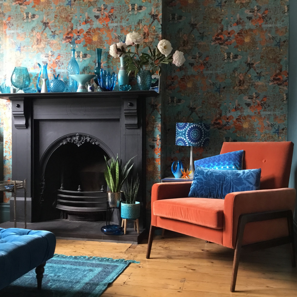 Cette image montre un salon vintage de taille moyenne avec un mur bleu, un sol en bois brun et du papier peint.
