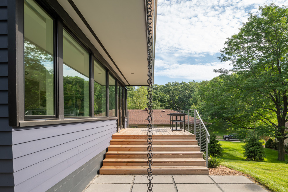 This is an example of a mid-sized midcentury backyard deck in Minneapolis with a roof extension.