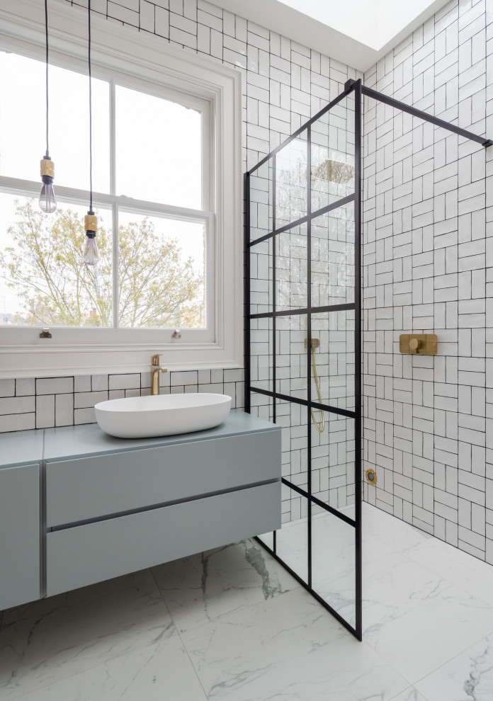 Mid-sized contemporary kids bathroom in London with flat-panel cabinets, blue cabinets, white tile, an open shower, blue benchtops, a curbless shower, a vessel sink and white floor.