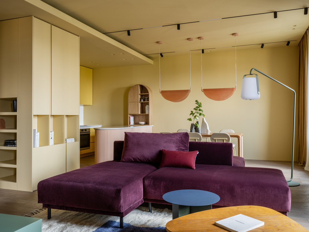 На фото: открытая гостиная комната в современном стиле с паркетным полом среднего тона и телевизором на стене с