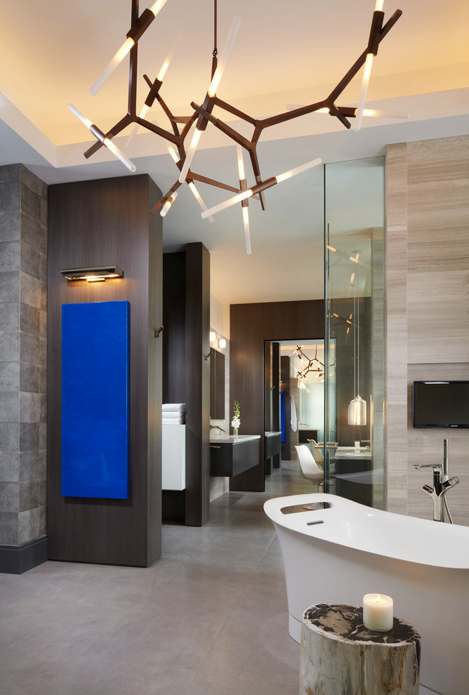 Inspiration for a contemporary bathroom in Miami with a freestanding tub and stone tile.