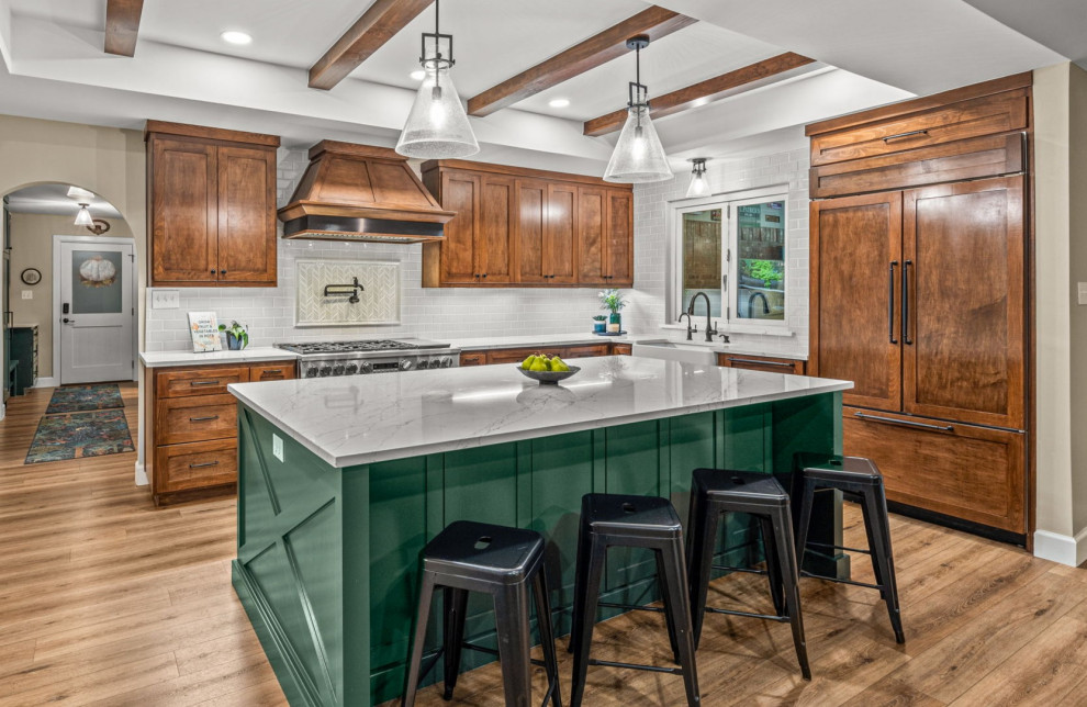 Inspiration for a farmhouse l-shaped medium tone wood floor, brown floor and exposed beam kitchen remodel in Dallas with a farmhouse sink, shaker cabinets, medium tone wood cabinets, white backsplash, subway tile backsplash, paneled appliances, an island and white countertops