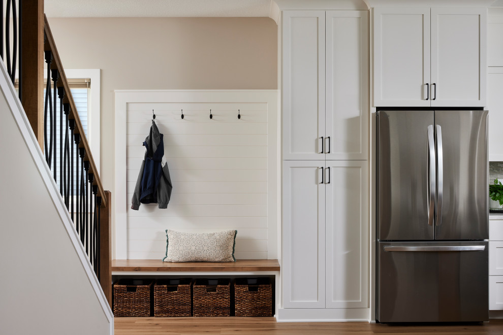 Example of a small transitional vinyl floor, brown floor and shiplap wall foyer design in Minneapolis with beige walls and a white front door