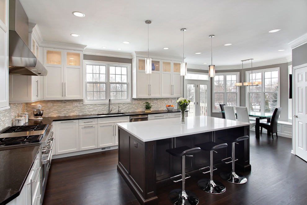 Example of a transitional l-shaped medium tone wood floor eat-in kitchen design in Chicago with an undermount sink, shaker cabinets, stainless steel appliances and an island