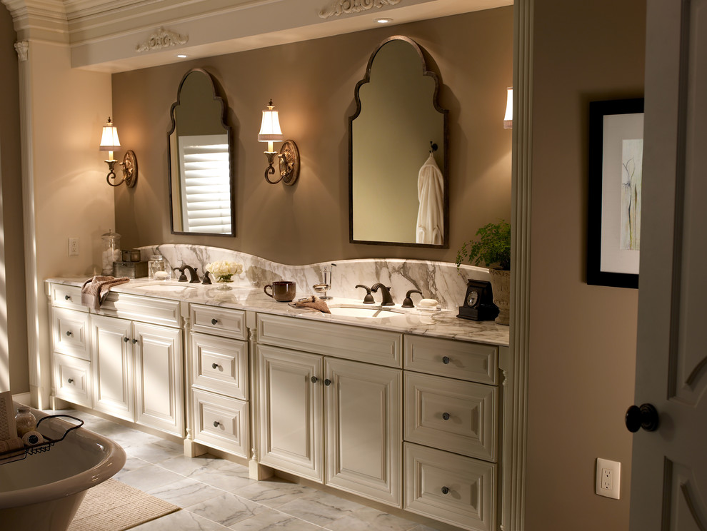 Mid-sized traditional master bathroom in New York with raised-panel cabinets, white cabinets, a claw-foot tub, brown walls, marble floors, an undermount sink and marble benchtops.