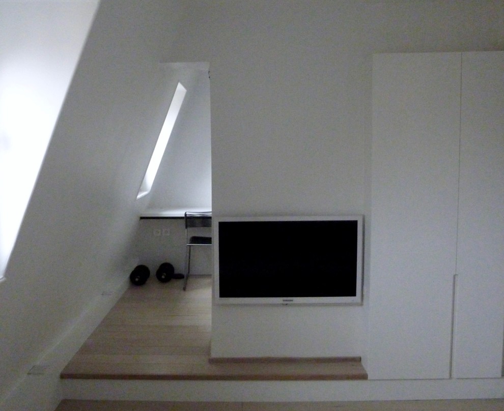 Photo of a small contemporary loft-style bedroom in Paris with white walls, light hardwood floors and beige floor.