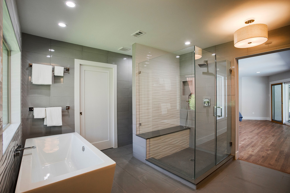 Inspiration for a large contemporary master bathroom in Dallas with flat-panel cabinets, light wood cabinets, a freestanding tub, gray tile, porcelain tile, porcelain floors, an undermount sink, engineered quartz benchtops, grey floor and a hinged shower door.