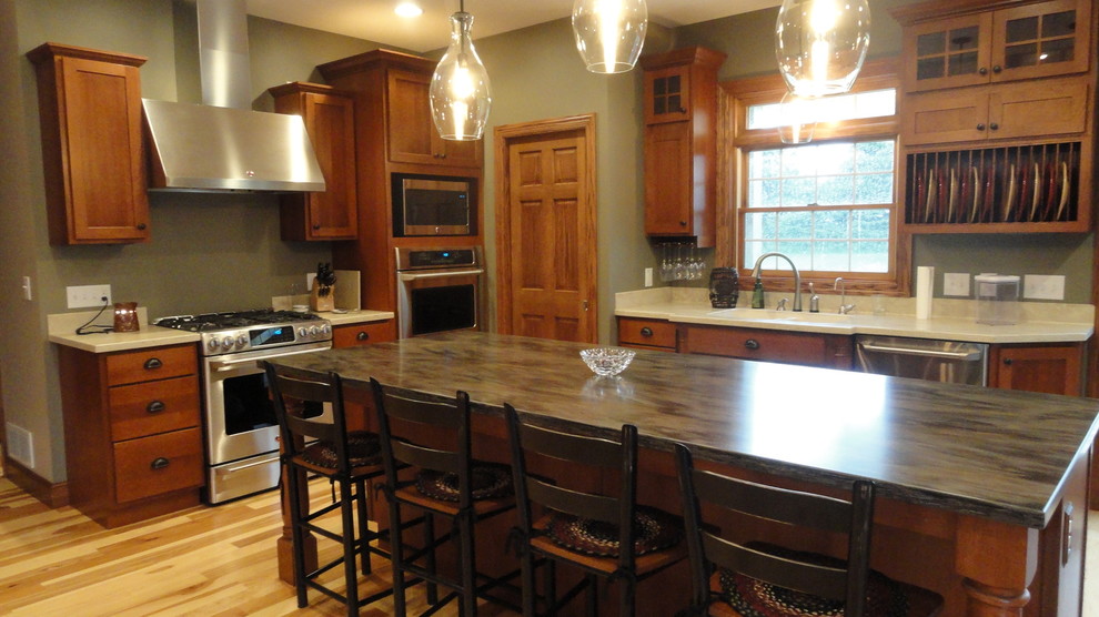 Photo of a large transitional l-shaped open plan kitchen in Other with an undermount sink, shaker cabinets, medium wood cabinets, limestone benchtops, stainless steel appliances, light hardwood floors, with island and beige floor.