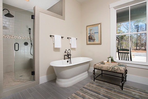 Design ideas for a mid-sized traditional master bathroom in Charleston with a freestanding tub, beige tile, beige walls and porcelain floors.