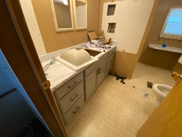 Inspiration for a large l-shaped eat-in kitchen remodel with a drop-in sink, flat-panel cabinets, gray cabinets, laminate countertops, no island and white countertops
