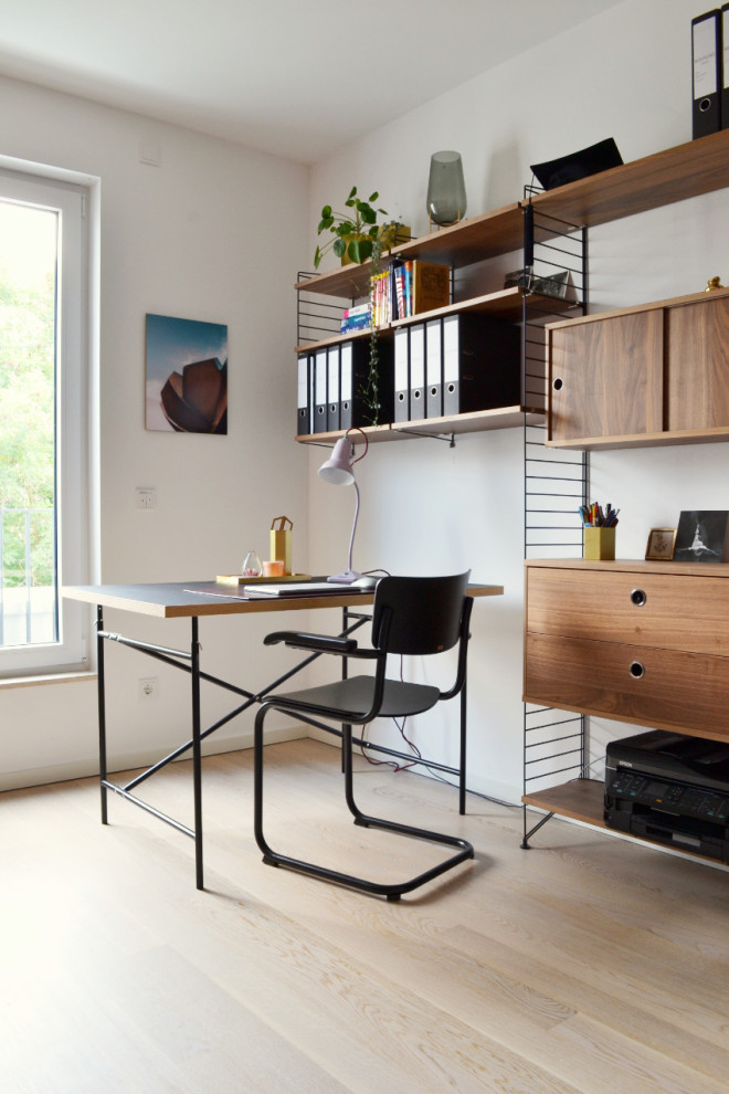 Mid-sized contemporary study room in Cologne with white walls, a freestanding desk and beige floor.