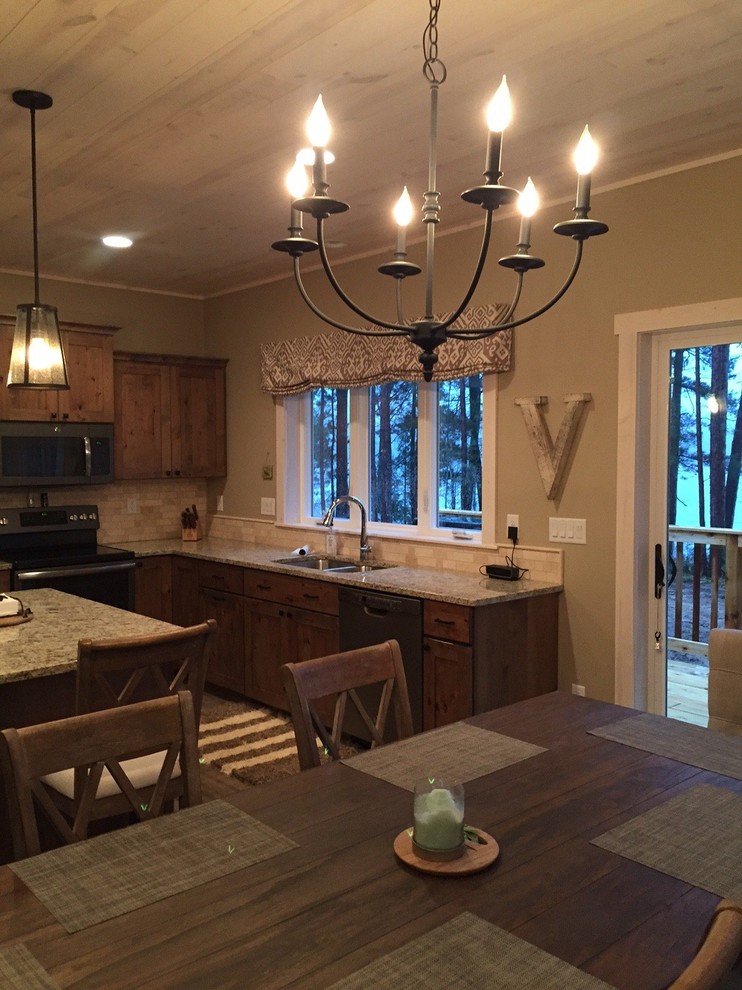 Mid-sized mountain style l-shaped open concept kitchen photo with an undermount sink, recessed-panel cabinets, granite countertops, beige backsplash and an island