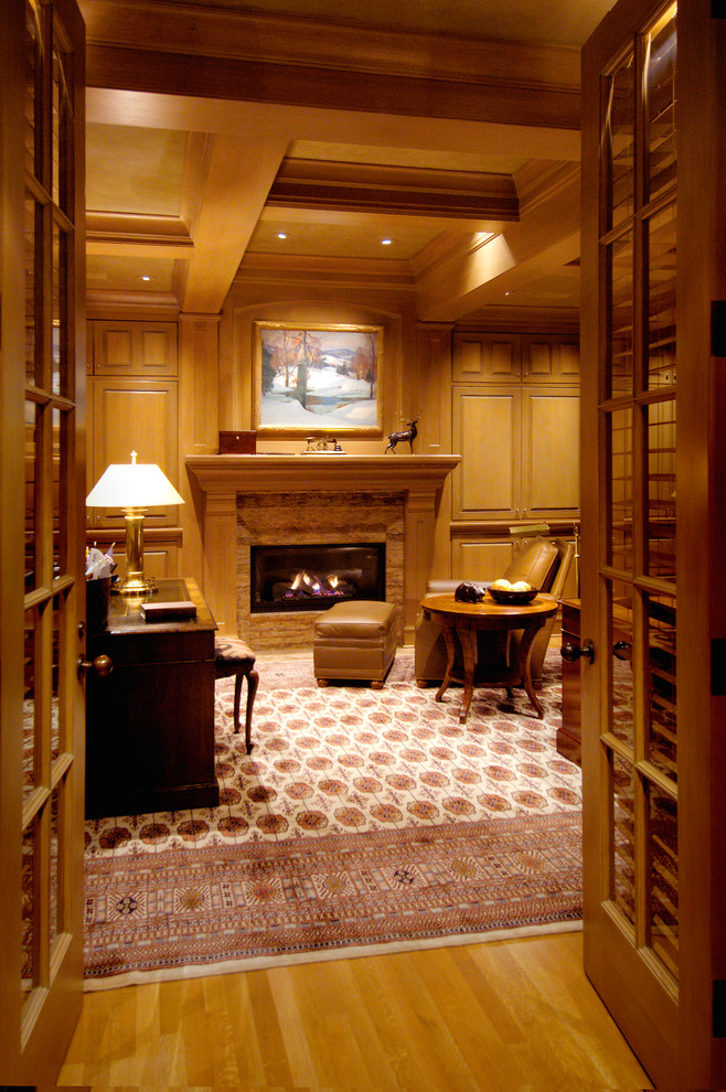 This is an example of a large traditional study room in Seattle with a standard fireplace, a wood fireplace surround, a freestanding desk, brown walls, medium hardwood floors and brown floor.