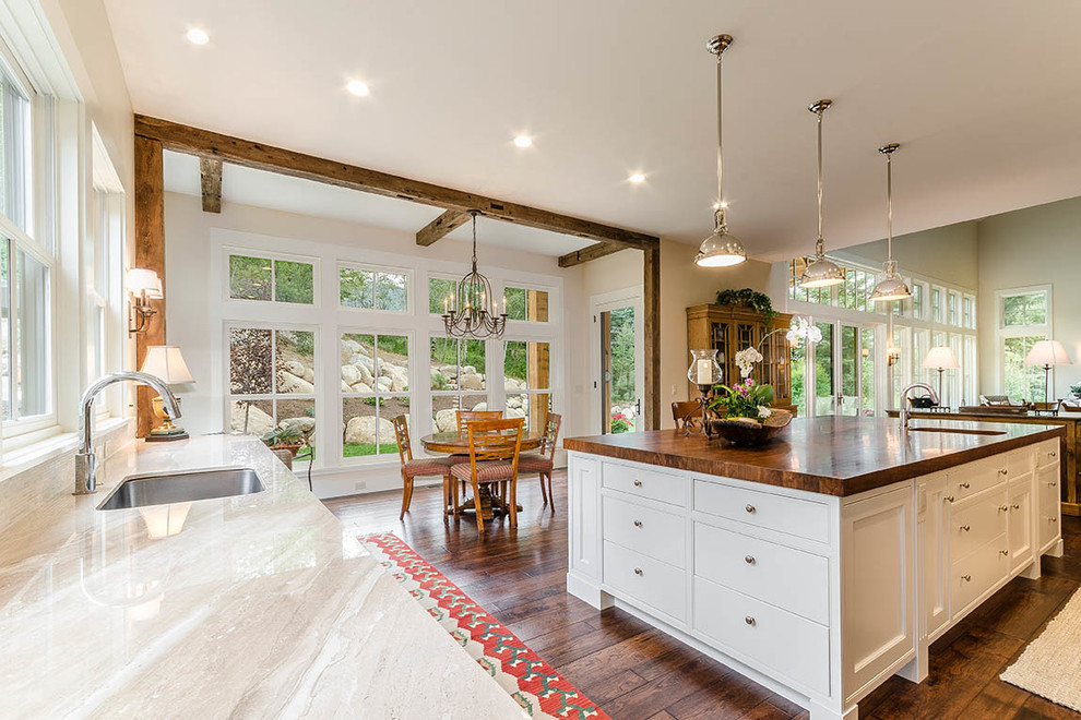 Huge transitional l-shaped dark wood floor and brown floor eat-in kitchen photo with an undermount sink, shaker cabinets, white cabinets, wood countertops, gray backsplash, matchstick tile backsplash, stainless steel appliances and an island