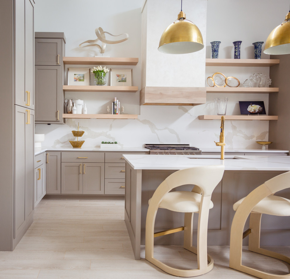 Example of a mid-sized transitional u-shaped brown floor open concept kitchen design in Houston with a drop-in sink, gray cabinets, white backsplash, stainless steel appliances, an island and white countertops