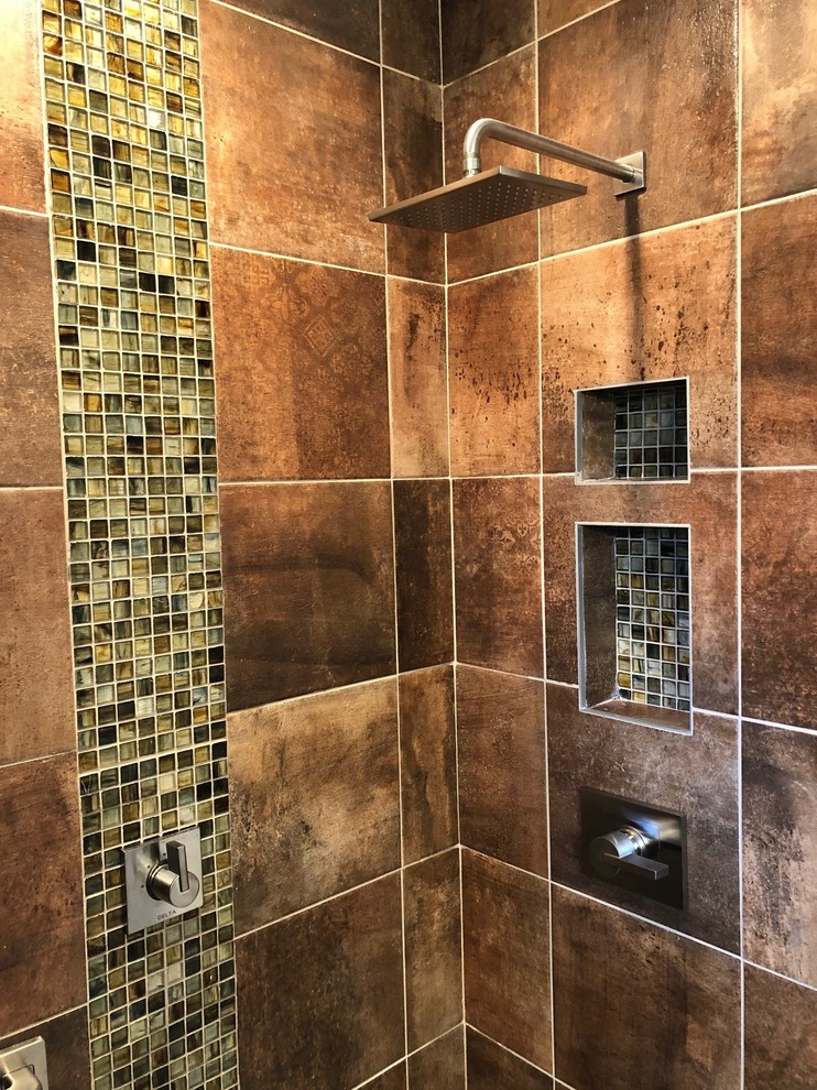 Photo of a mid-sized transitional 3/4 bathroom in Columbus with shaker cabinets, brown cabinets, an alcove shower, a two-piece toilet, orange tile, porcelain tile, grey walls, vinyl floors, an undermount sink, engineered quartz benchtops, grey floor, a hinged shower door and grey benchtops.