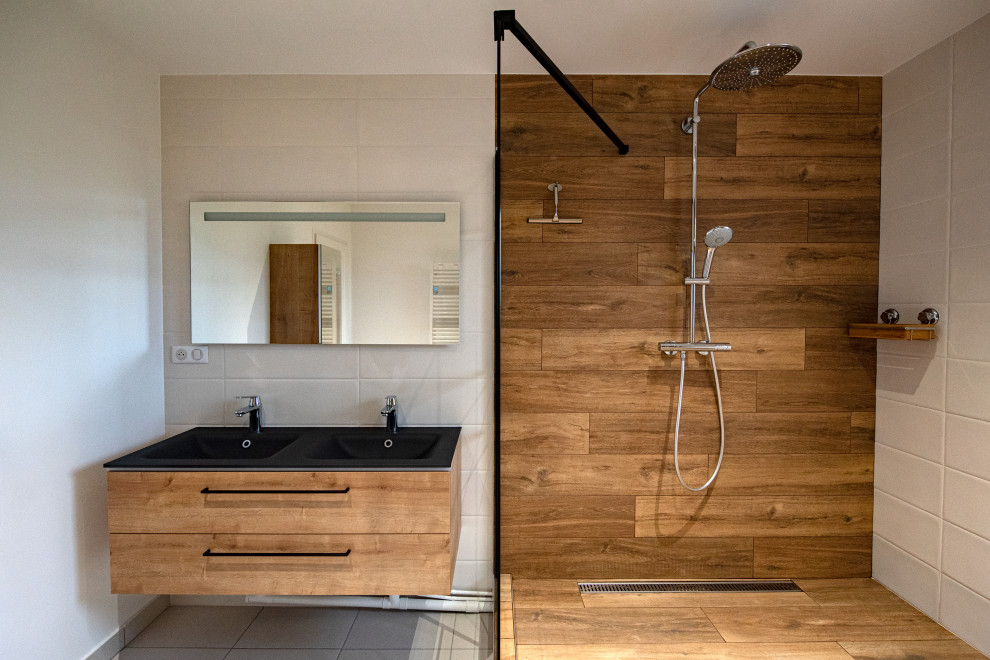 Inspiration for a large industrial master bathroom in Clermont-Ferrand with a curbless shower, a trough sink, glass benchtops and black benchtops.