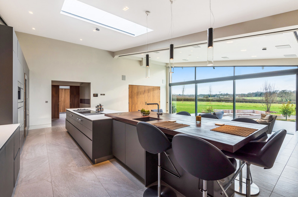 Photo of a contemporary galley open plan kitchen in Berkshire with flat-panel cabinets and an island.