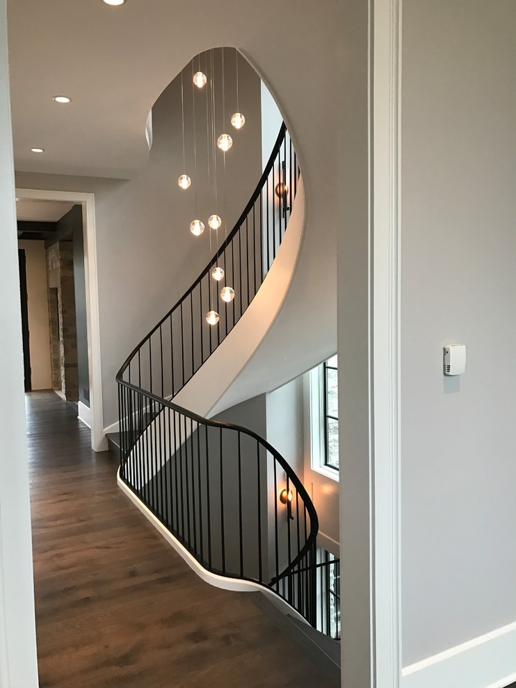 Design ideas for an expansive contemporary painted wood spiral staircase in Chicago with painted wood risers and metal railing.