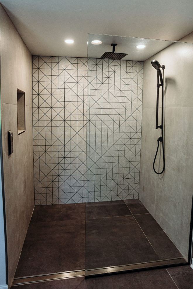 This is an example of a large modern master bathroom in Milwaukee with flat-panel cabinets, white cabinets, a freestanding tub, a curbless shower, a one-piece toilet, gray tile, ceramic tile, white walls, ceramic floors, a drop-in sink, granite benchtops, grey floor, an open shower, grey benchtops, a shower seat, a double vanity, a built-in vanity and vaulted.