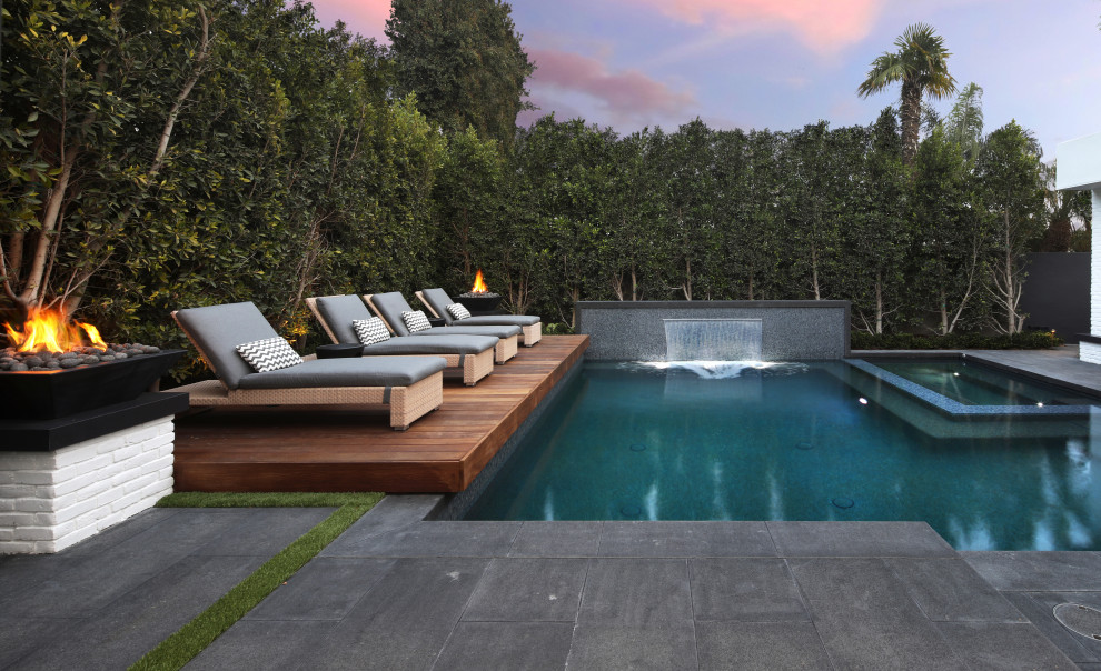 Large contemporary backyard rectangular pool in Orange County with a hot tub and natural stone pavers.