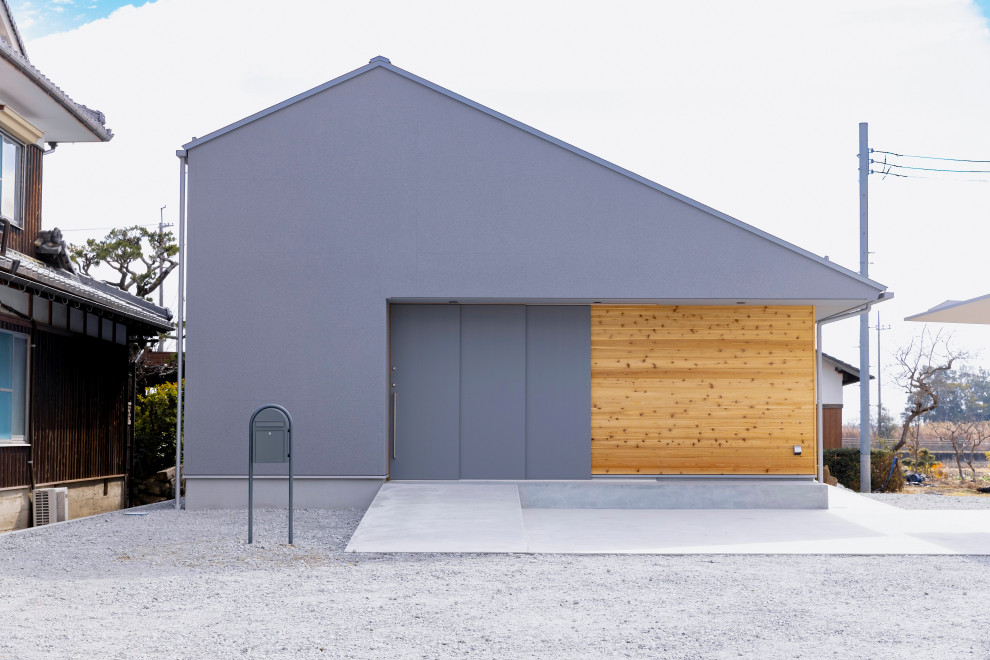 Идея дизайна: одноэтажный, серый частный загородный дом среднего размера в скандинавском стиле с облицовкой из бетона, вальмовой крышей, металлической крышей, серой крышей и отделкой дранкой