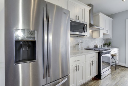 Small transitional galley dark wood floor eat-in kitchen photo in DC Metro with an undermount sink, shaker cabinets, white cabinets, marble countertops, gray backsplash, stainless steel appliances and an island