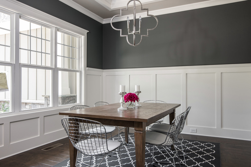 This is an example of a mid-sized arts and crafts separate dining room in Charlotte with grey walls, dark hardwood floors, no fireplace and brown floor.