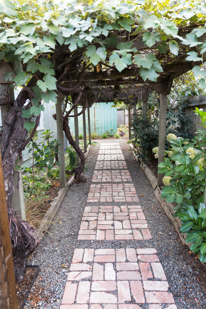 Photo of a mid-sized rustic drought-tolerant and full sun side yard gravel garden path.