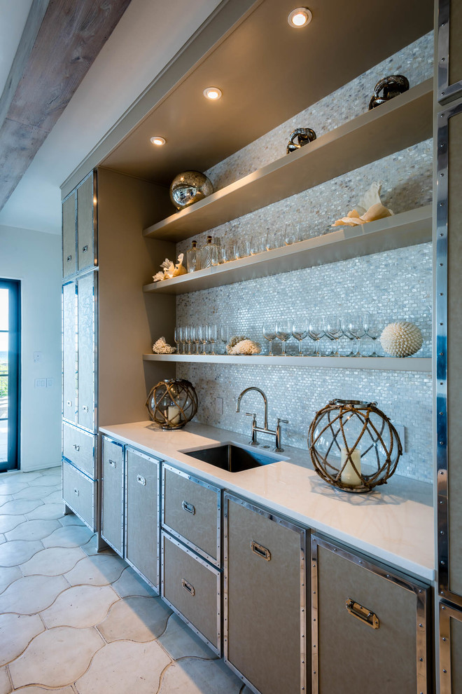 Inspiration for a mid-sized transitional single-wall wet bar in Miami with an undermount sink, beige cabinets, solid surface benchtops, grey splashback, mosaic tile splashback, concrete floors, beige floor and white benchtop.