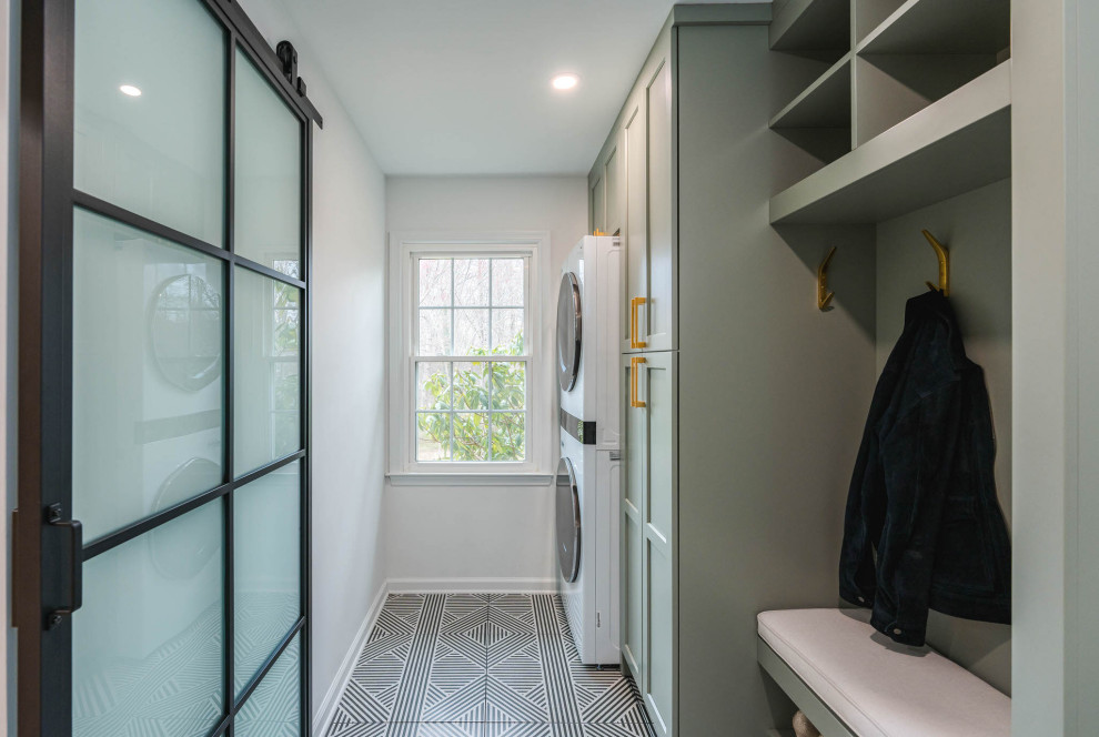 Esempio di una piccola lavanderia multiuso classica con ante in stile shaker, ante verdi, pareti bianche, pavimento in gres porcellanato, lavatrice e asciugatrice a colonna e pavimento nero