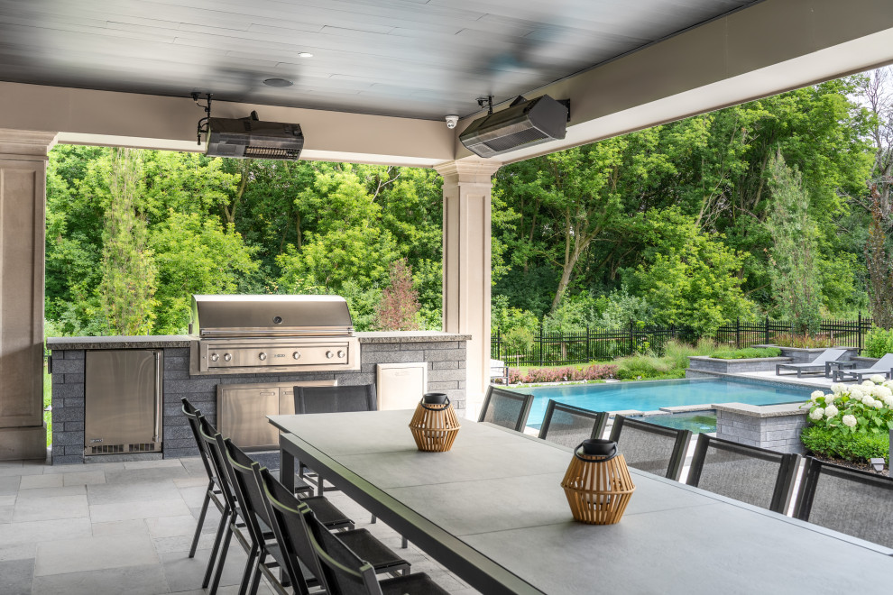 Photo of a traditional back patio in Toronto with an outdoor kitchen, concrete paving and a roof extension.