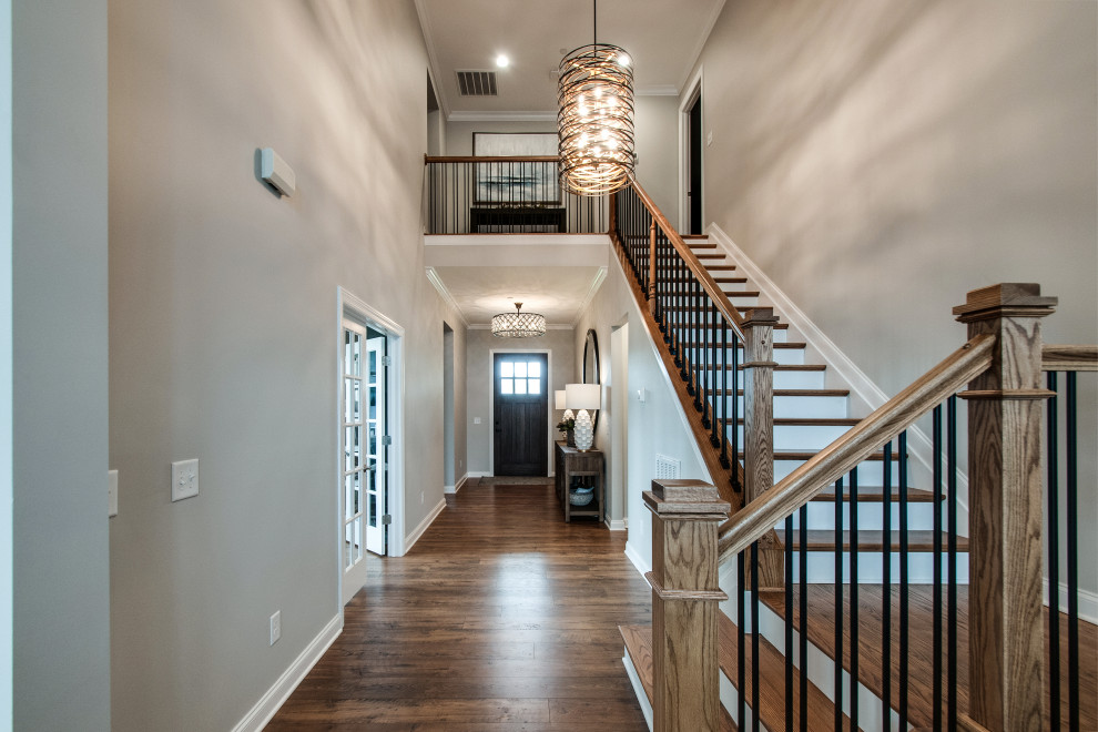 This is an example of a mid-sized transitional foyer in Nashville with grey walls, medium hardwood floors, a single front door, a dark wood front door, brown floor and vaulted.