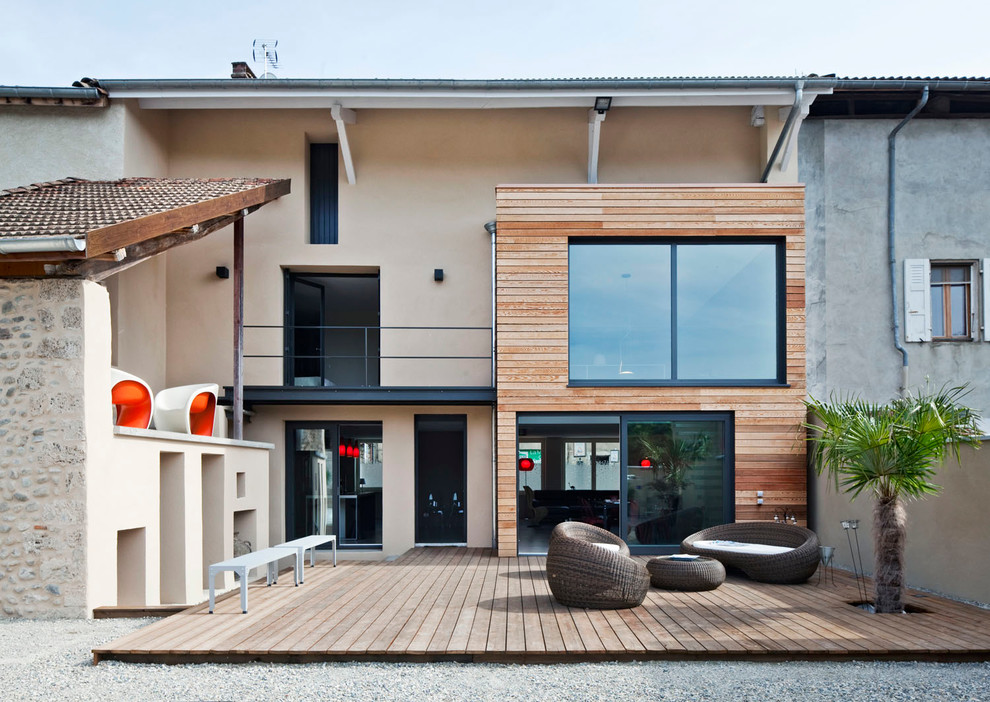 This is an example of a mid-sized contemporary three-storey beige exterior in Grenoble with wood siding and a flat roof.