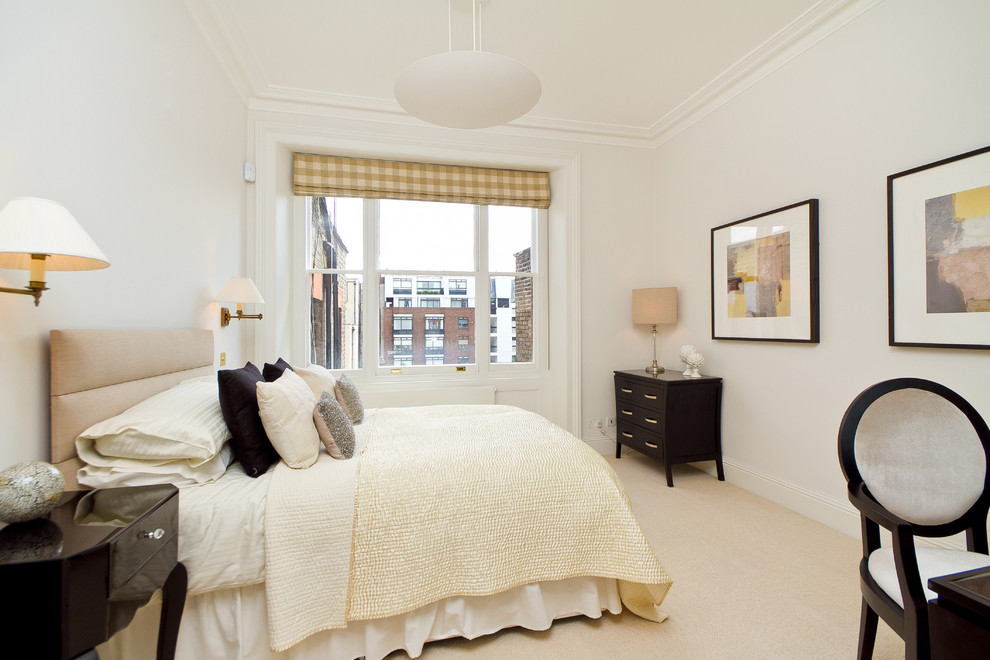 This is an example of a contemporary bedroom in London with white walls, carpet and no fireplace.