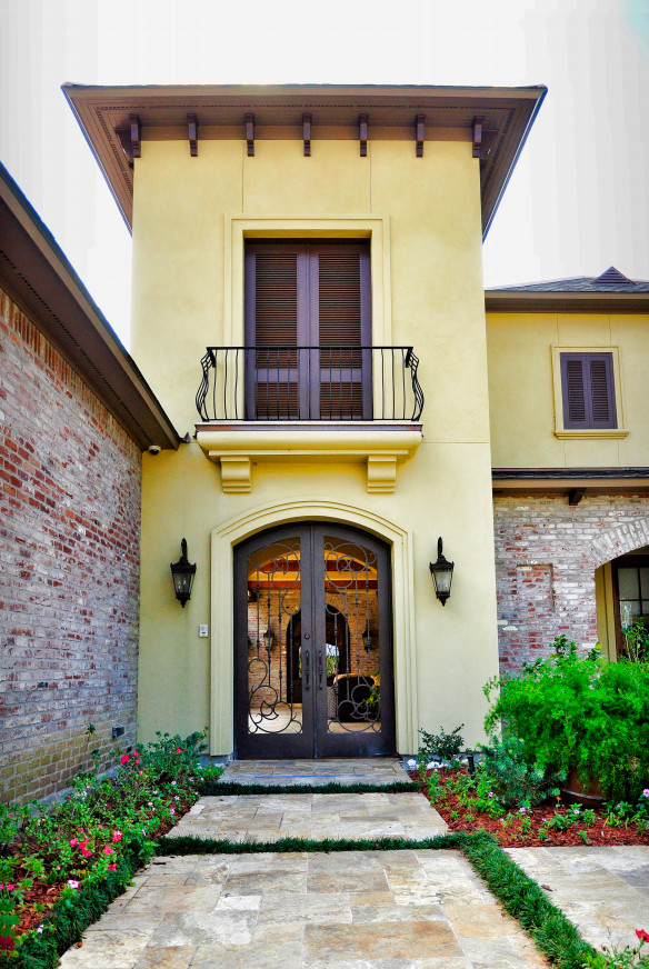 Inspiration for a large mediterranean front door in New Orleans with yellow walls, limestone floors, a double front door and a metal front door.