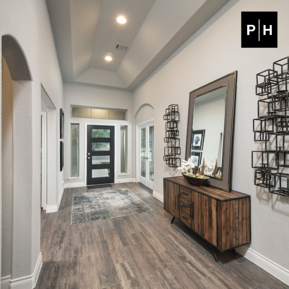 Entry hall - medium tone wood floor and vaulted ceiling entry hall idea in Austin with gray walls and a dark wood front door