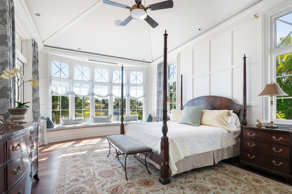Inspiration for a large beach style master bedroom in Tampa with white walls, dark hardwood floors, no fireplace and brown floor.