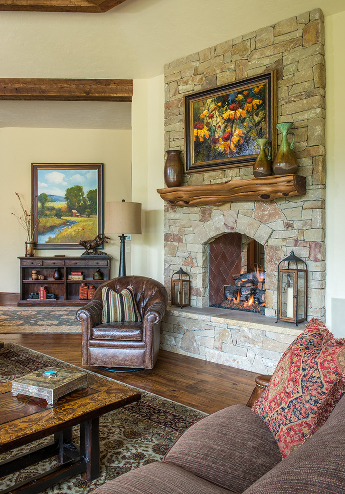 Photo of an expansive country open concept living room in Dallas with medium hardwood floors, a two-sided fireplace, a stone fireplace surround and a wall-mounted tv.