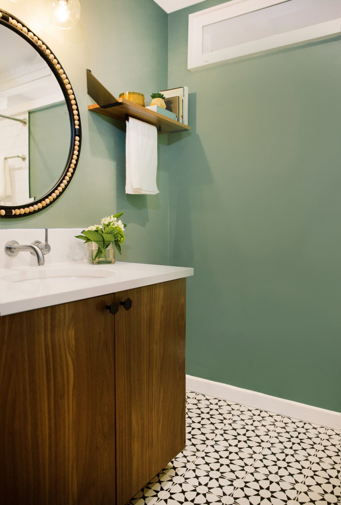 Inspiration for a transitional 3/4 bathroom in Austin with medium wood cabinets, an alcove tub, a shower/bathtub combo, a one-piece toilet, green walls, ceramic floors, an undermount sink, black floor, a shower curtain, white benchtops, a single vanity and a built-in vanity.