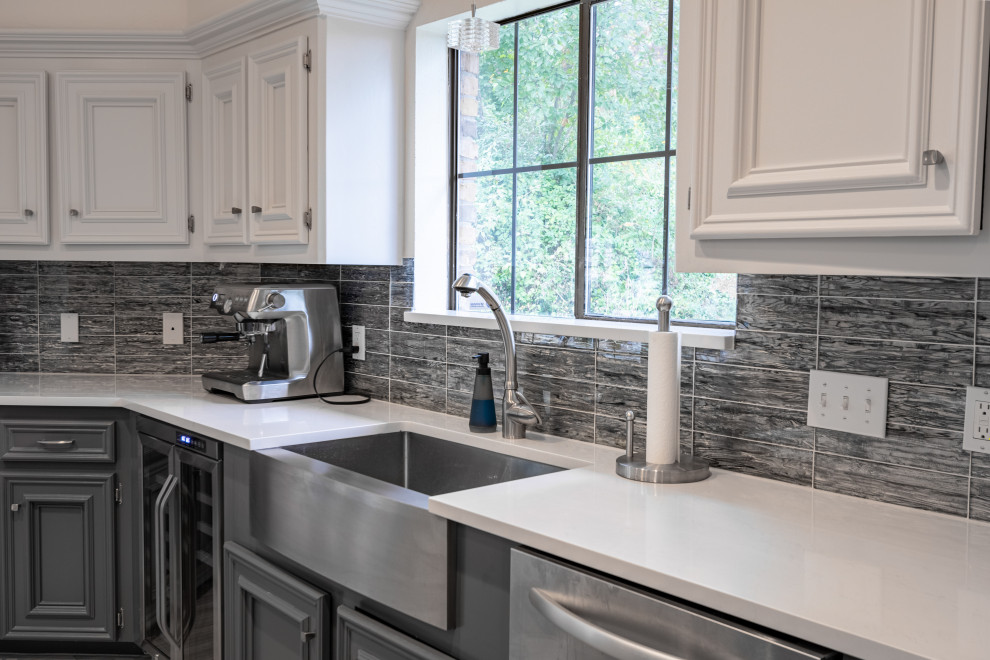 Enclosed kitchen - mid-sized transitional u-shaped ceramic tile and gray floor enclosed kitchen idea in Austin with a farmhouse sink, recessed-panel cabinets, white cabinets, quartzite countertops, blue backsplash, glass tile backsplash, stainless steel appliances, an island and white countertops