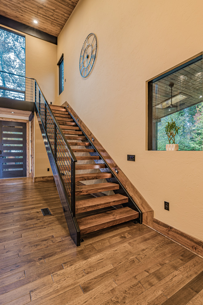 Design ideas for a large country wood straight staircase in Atlanta with open risers and cable railing.