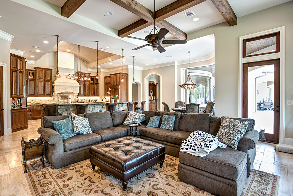 Large open concept family room in Houston with beige walls, limestone floors and beige floor.