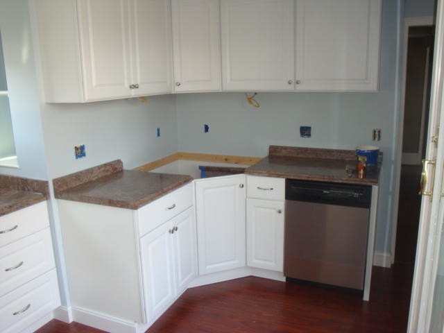 Medium tone wood floor kitchen photo in Boston with raised-panel cabinets, white cabinets, granite countertops, blue backsplash, stainless steel appliances and no island