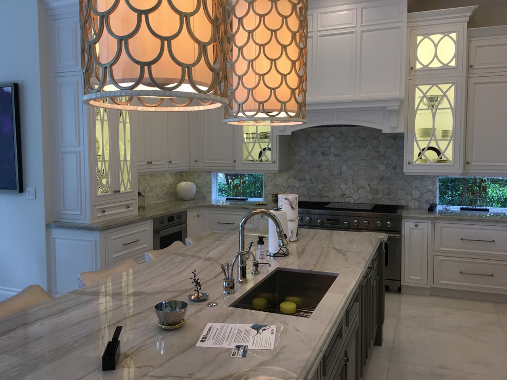 Example of a large transitional u-shaped marble floor and white floor eat-in kitchen design in Miami with an undermount sink, recessed-panel cabinets, white cabinets, marble countertops, gray backsplash, stone tile backsplash, paneled appliances and an island