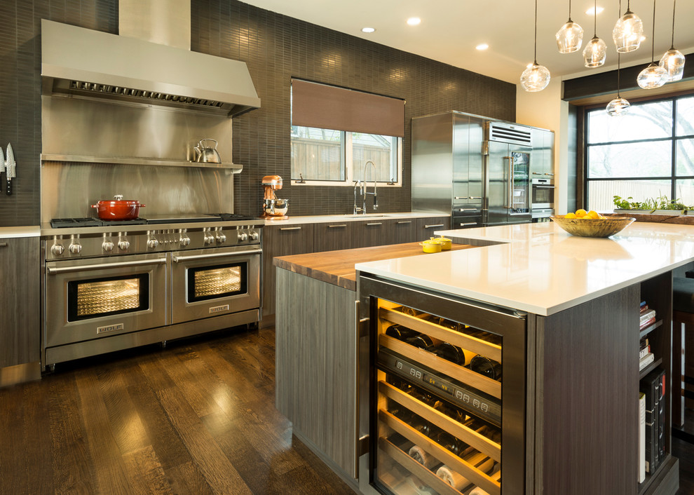 Large contemporary eat-in kitchen in Dallas with flat-panel cabinets, dark wood cabinets, stainless steel appliances, dark hardwood floors, with island, wood benchtops, black splashback, mosaic tile splashback and white benchtop.