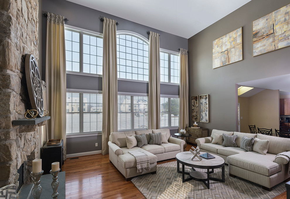 Inspiration for a large transitional open concept and formal medium tone wood floor and brown floor living room remodel in Philadelphia with gray walls, a standard fireplace, a stone fireplace and a tv stand