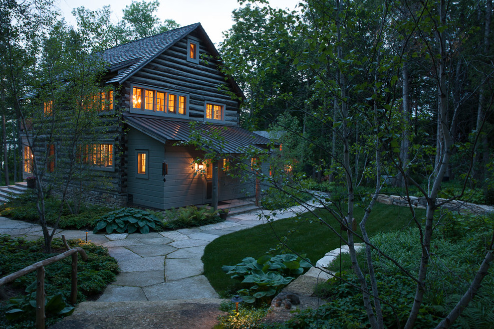 Inspiration for a large rustic partial sun front yard stone landscaping for summer.
