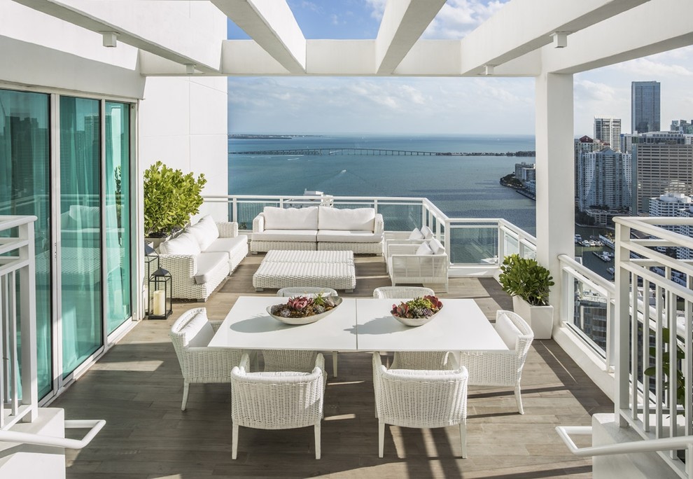 Photo of a mid-sized contemporary balcony in Miami with a pergola.