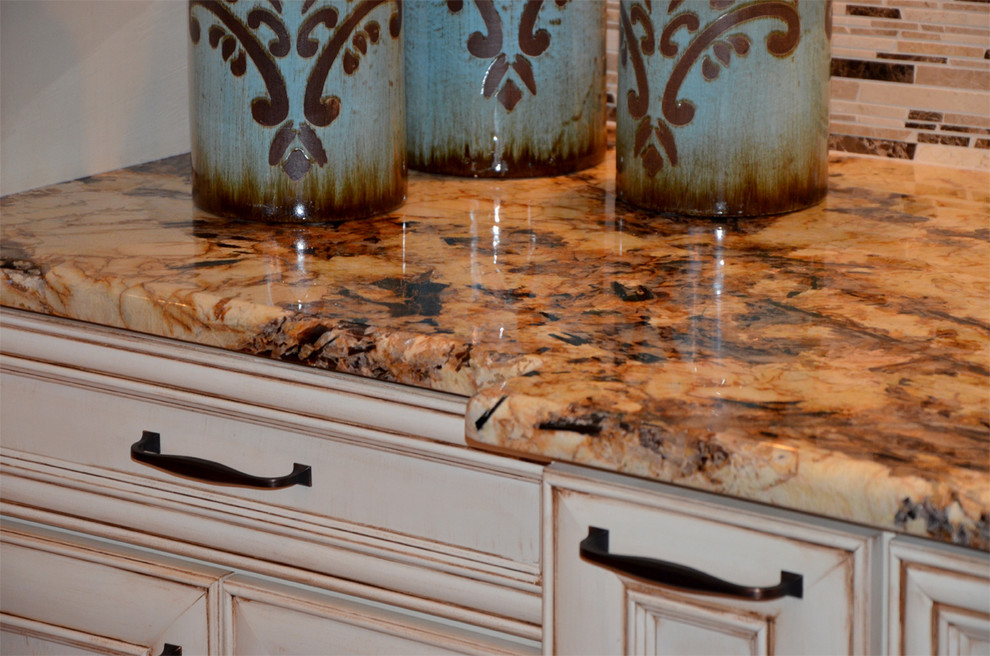 Large transitional medium tone wood floor open concept kitchen photo in Miami with a farmhouse sink, glass-front cabinets, white cabinets, granite countertops, multicolored backsplash, custom tile backsplash, paneled appliances, beige walls and an island
